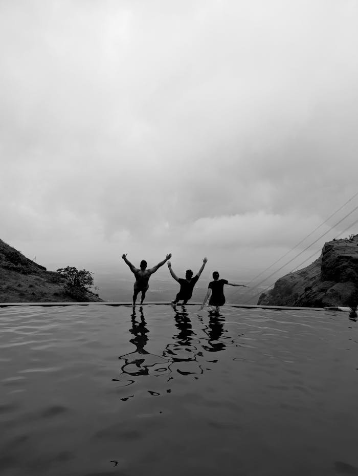 silhouetted-friends-celebrating-at-scenic-mountain-pool-32577587